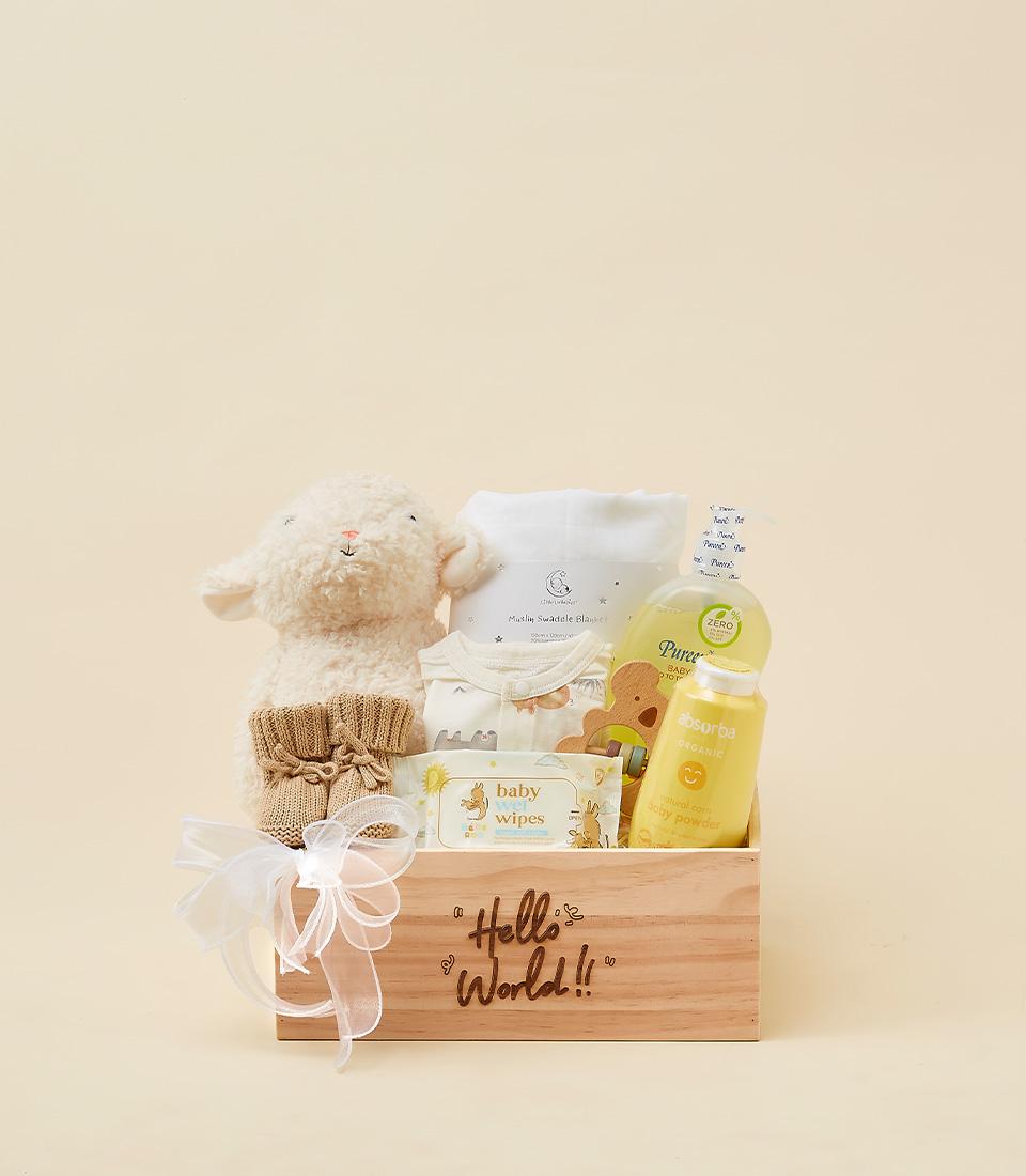 Newborn gift crate with plush lamb toy, muslin blanket, booties, and organic baby essentials
