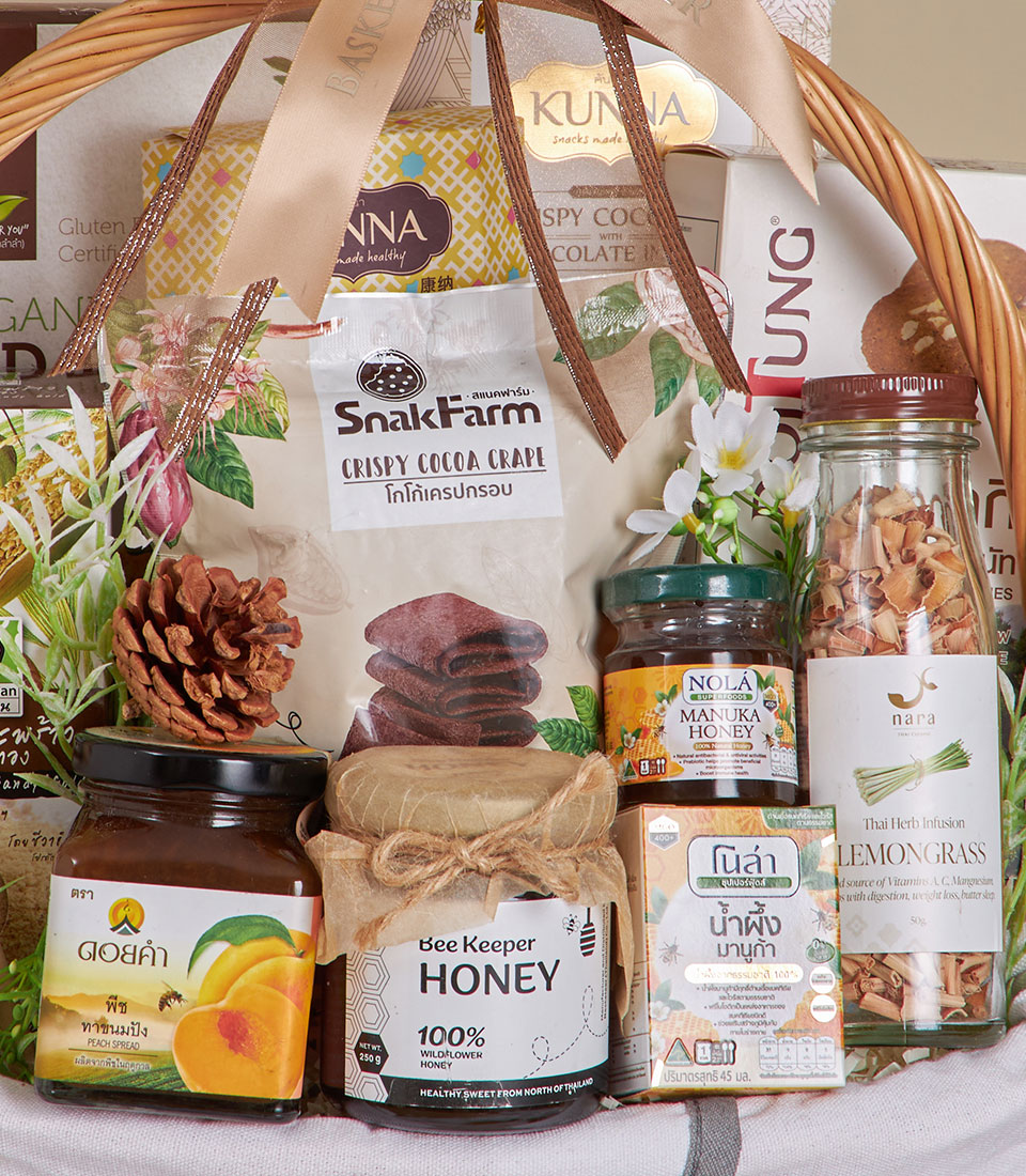 Light woven wicker basket with honey, gourmet spreads, and artisan treats tied with satin ribbon