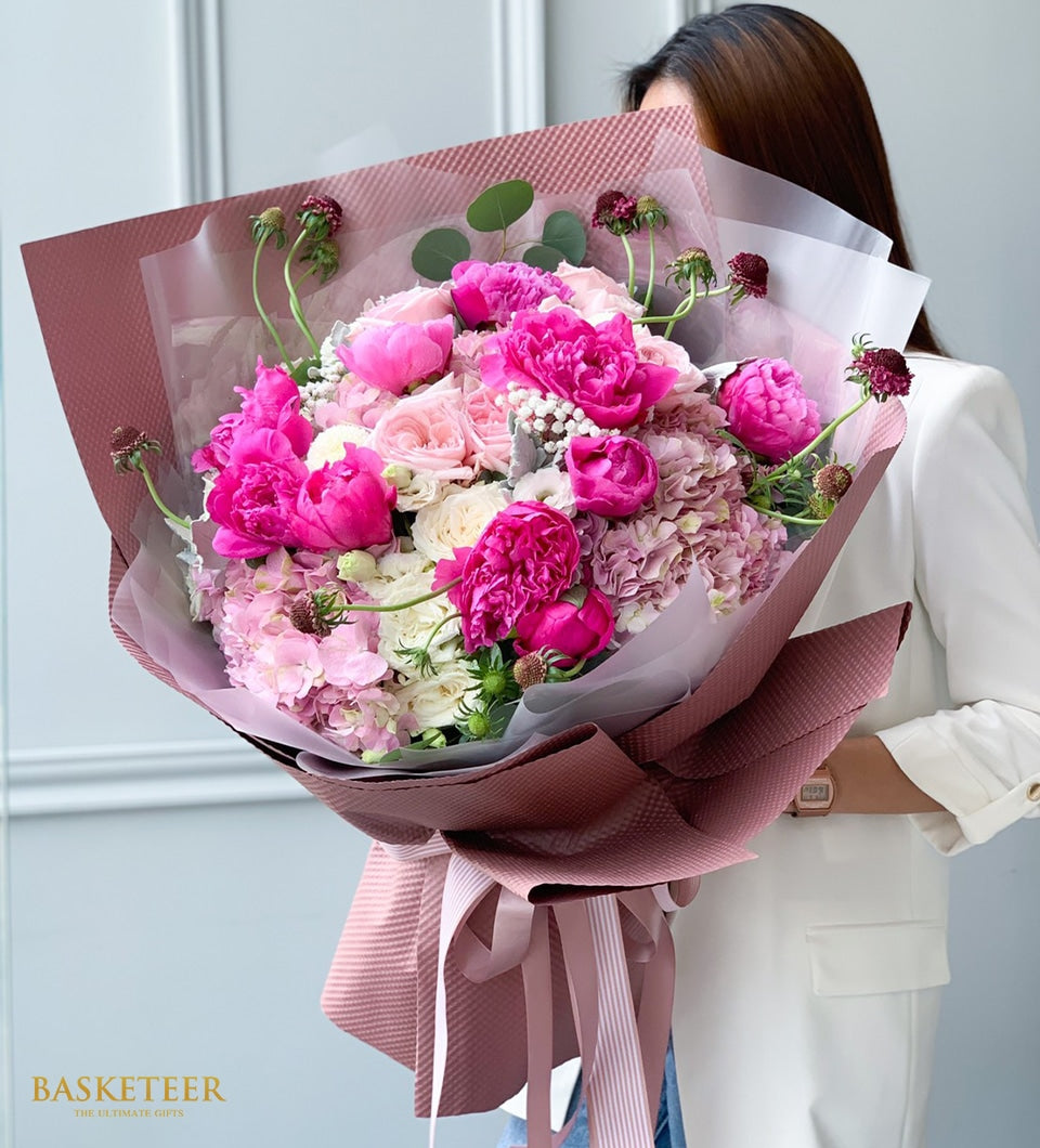 Luxury pink peony and rose bouquet with white hydrangeas in dusty rose wrapping