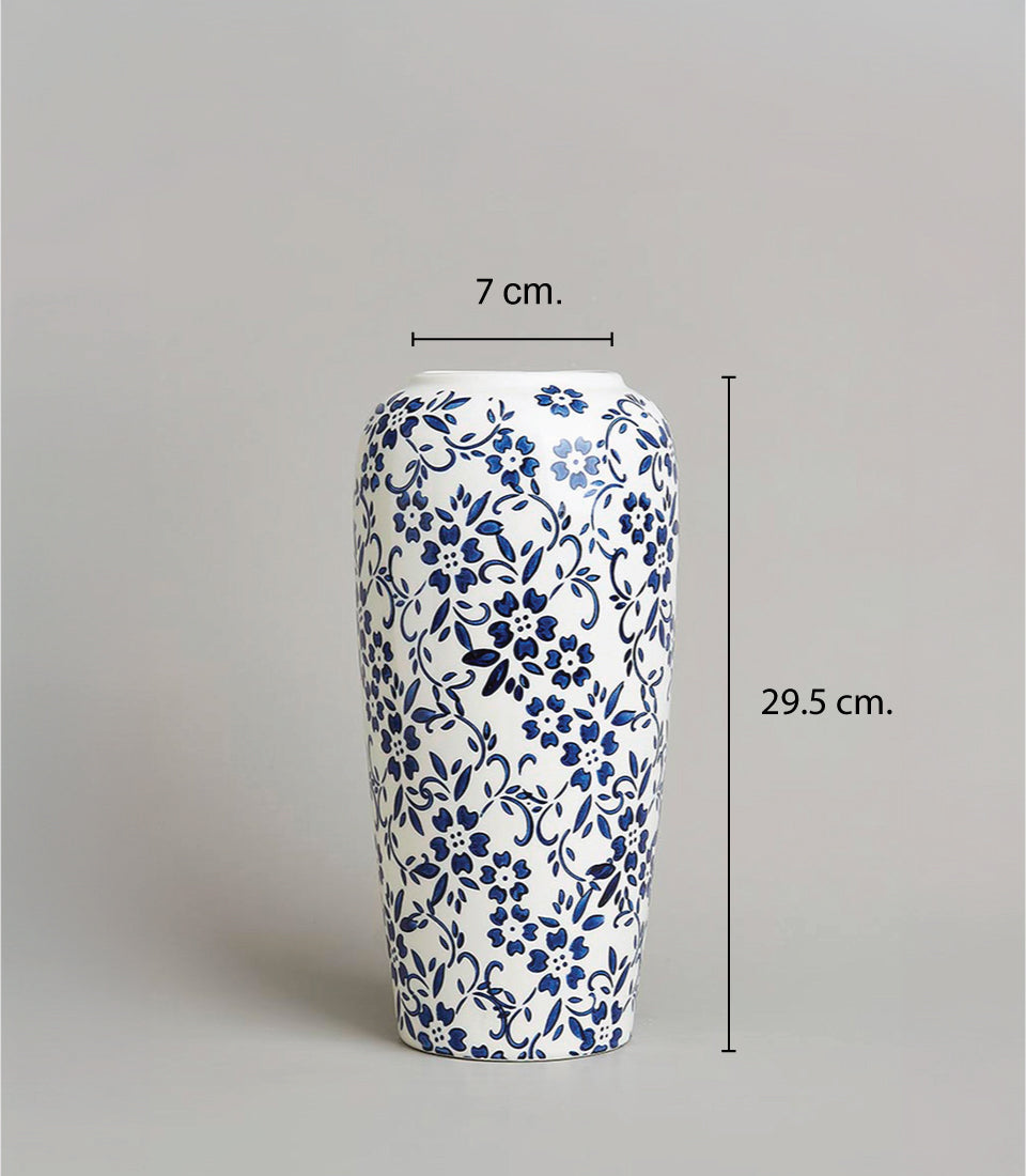 White ceramic vase with blue floral pattern and artificial orchids for elegant home décor