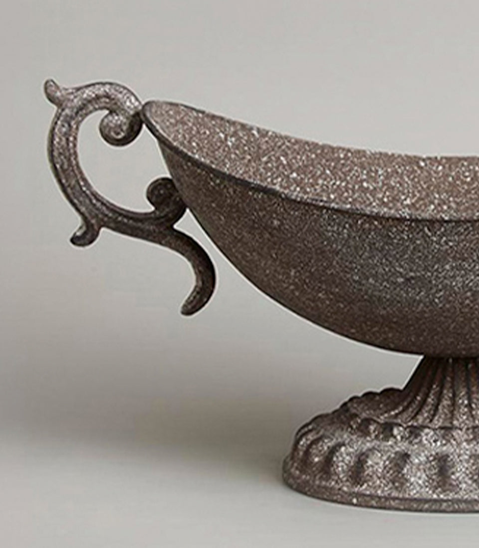 Ornate rustic metal urn vase with scrolled handle and aged bronze finish
