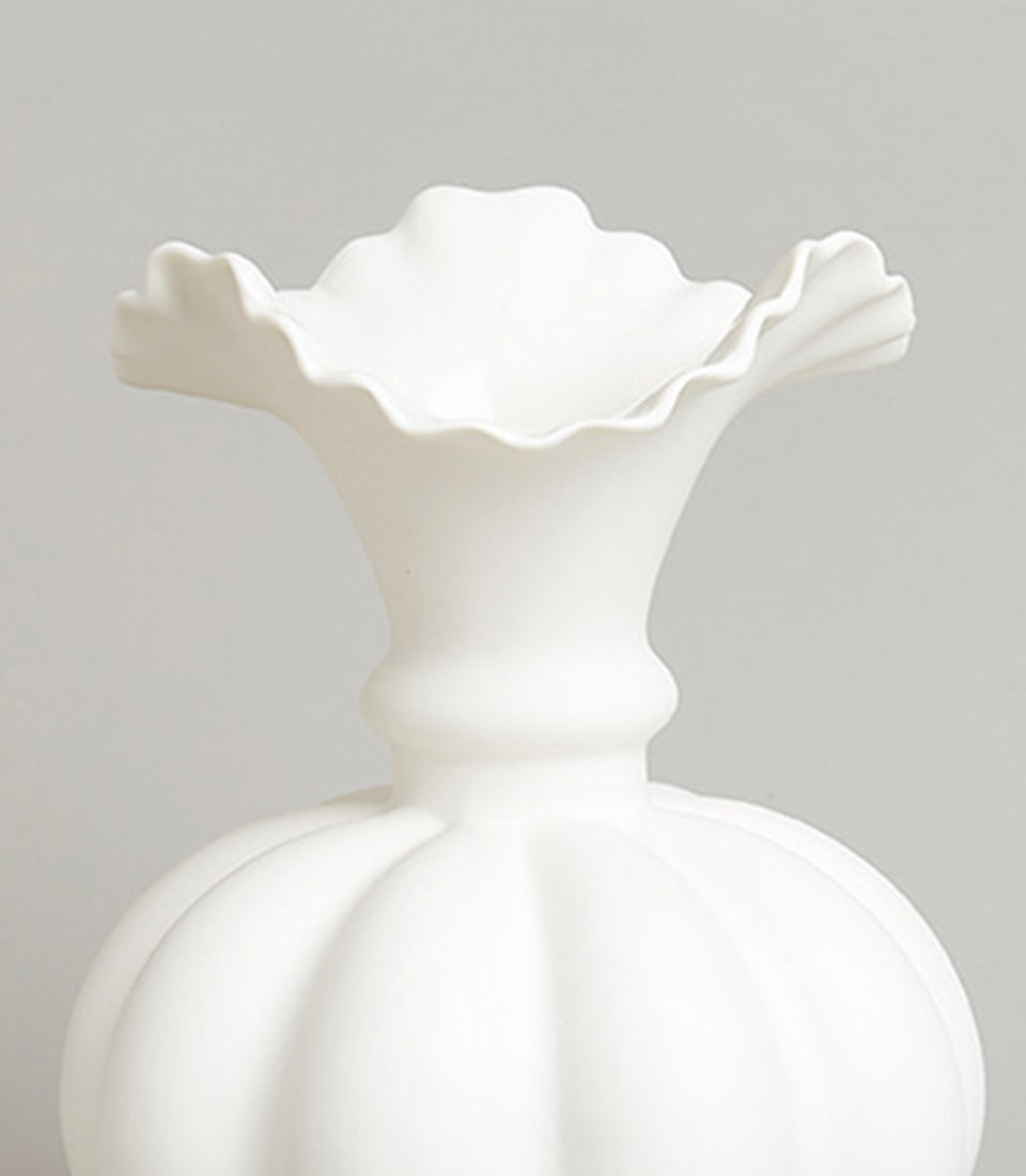 White ceramic sculptural vase with ruffled petal-shaped rim and fluted spherical body