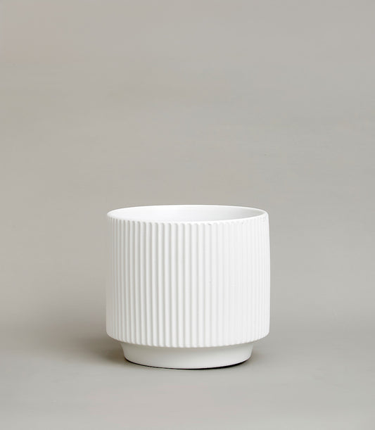 White ceramic vase with vertical fluted texture and minimalist cylindrical design