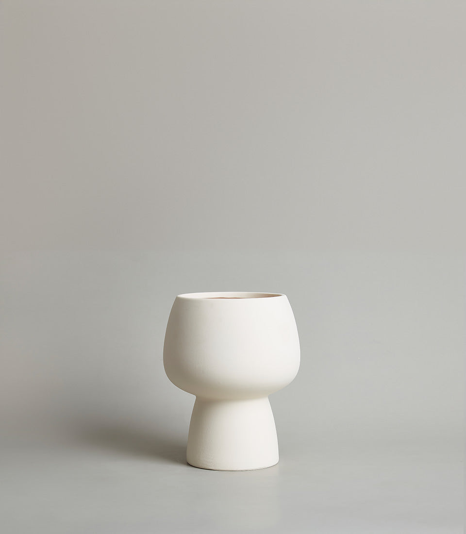 Modern matte white ceramic vase with rounded bulbous body and terracotta interior rim