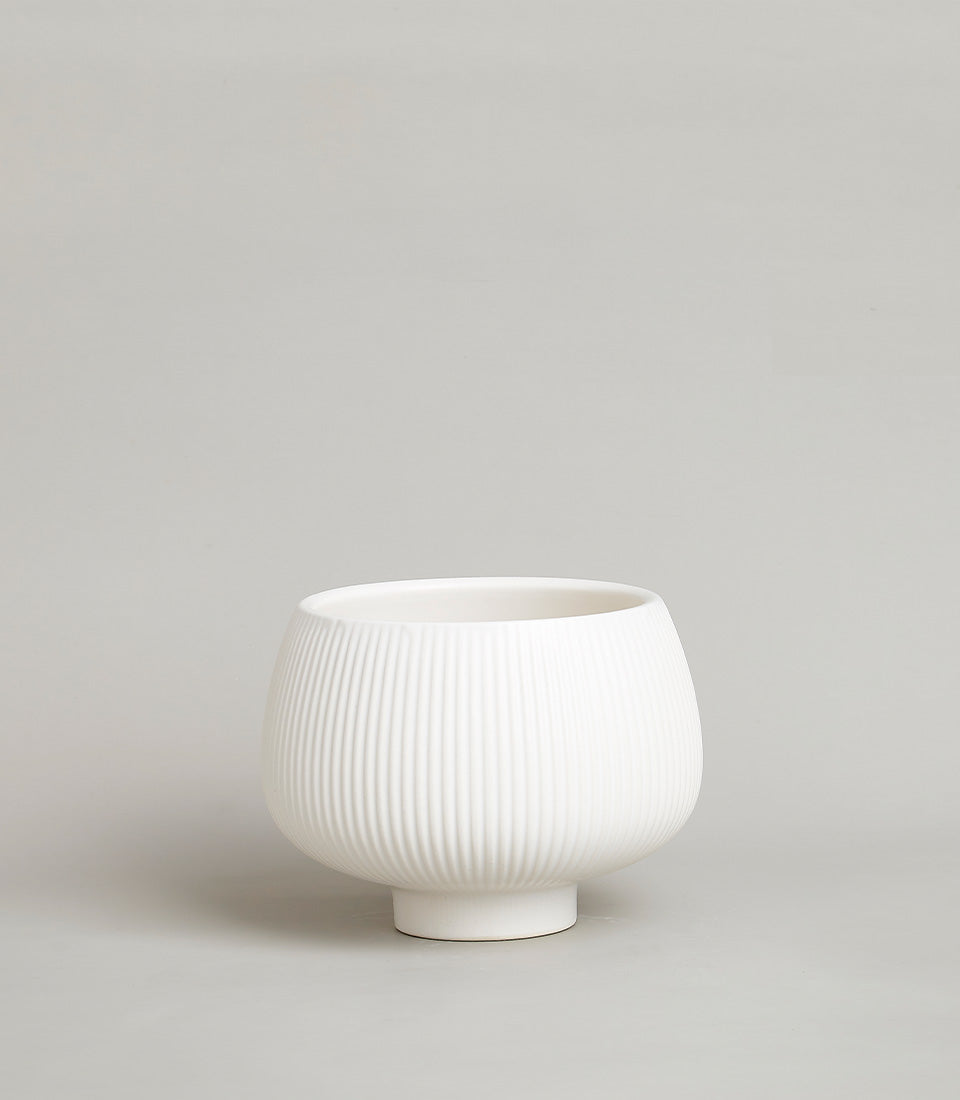 White ceramic fluted vase with pedestal base, minimalist modern design for home decor or gifting