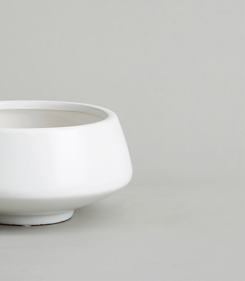 White ceramic bowl-shaped vase with matte finish and contemporary design