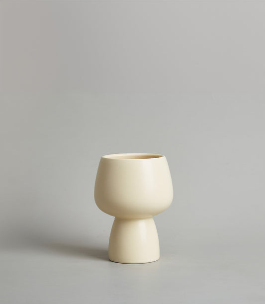 Cream ceramic chalice vase with rounded bulbous body and narrow cylindrical base