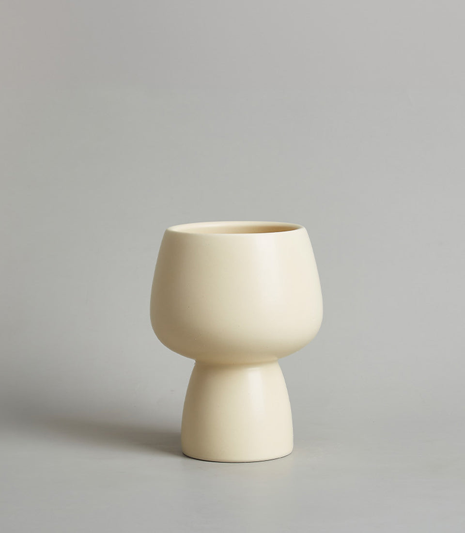 Cream ceramic chalice vase with rounded body and tapered neck, modern minimalist design