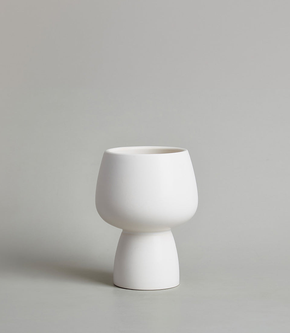 Minimalist white ceramic chalice vase with rounded upper bowl and cylindrical base