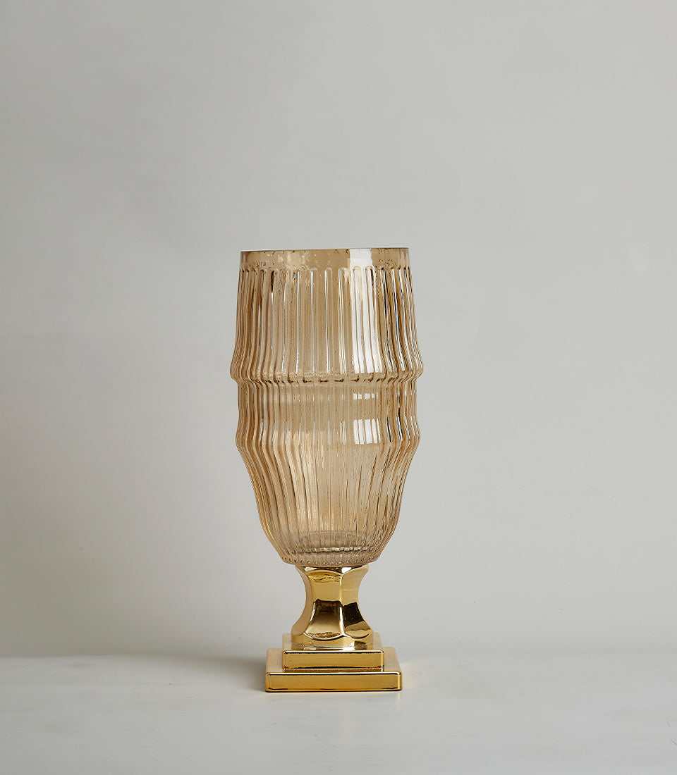 Tall amber glass vase with ribbed design and polished gold base, modern luxury home decor