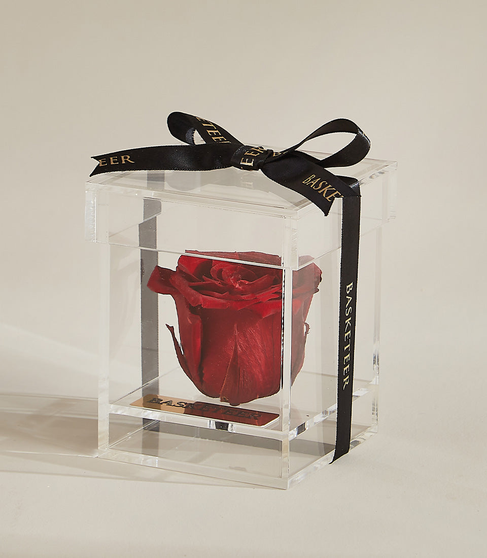 Deep red preserved rose in clear acrylic box with gold plaque and branded ribbon bow