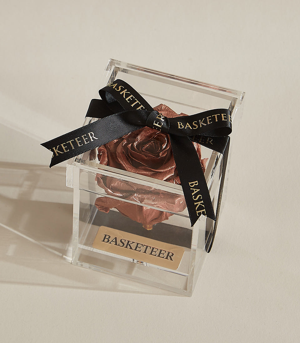 Deep bronze preserved rose in clear acrylic box with gold-embossed plaque, luxury Valentine's gift