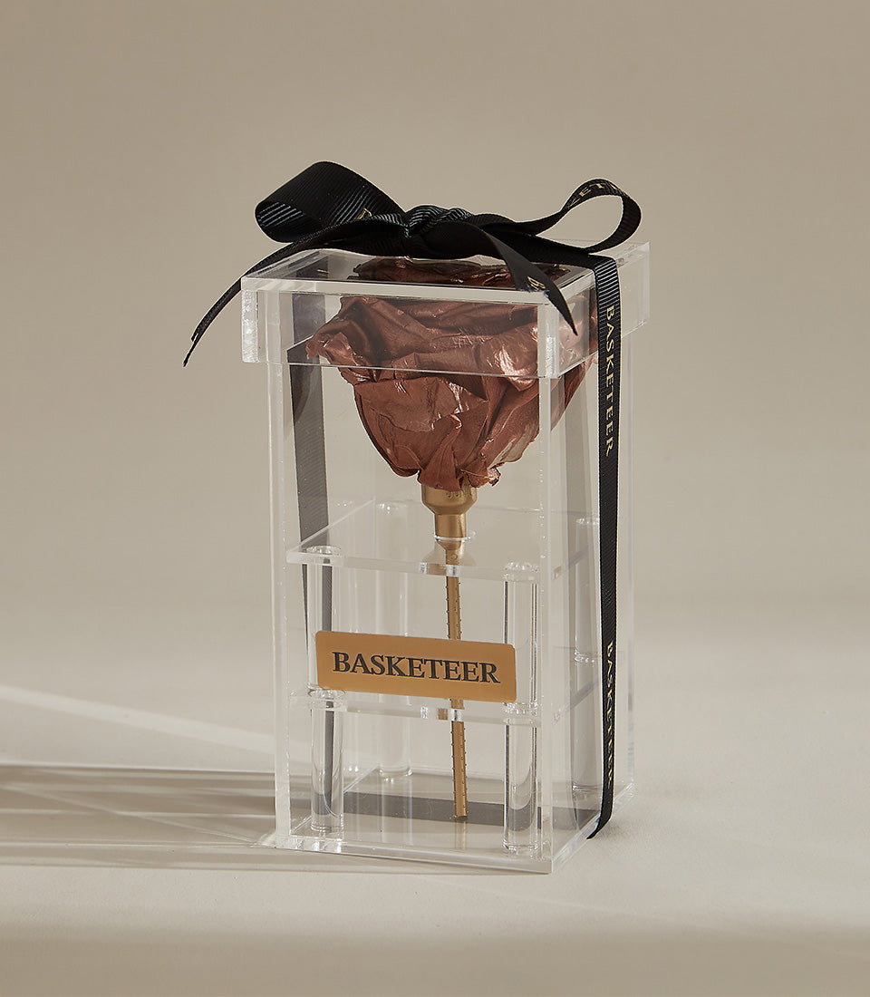Preserved brown rose in clear acrylic box with golden stem and black grosgrain ribbon bow