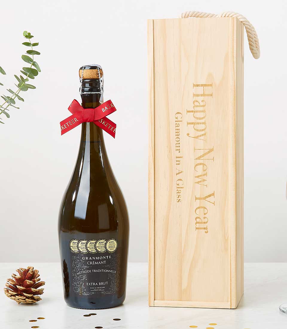 Award-winning Crémant sparkling wine in light wood gift box with rope handle, gold confetti and festive red ribbon