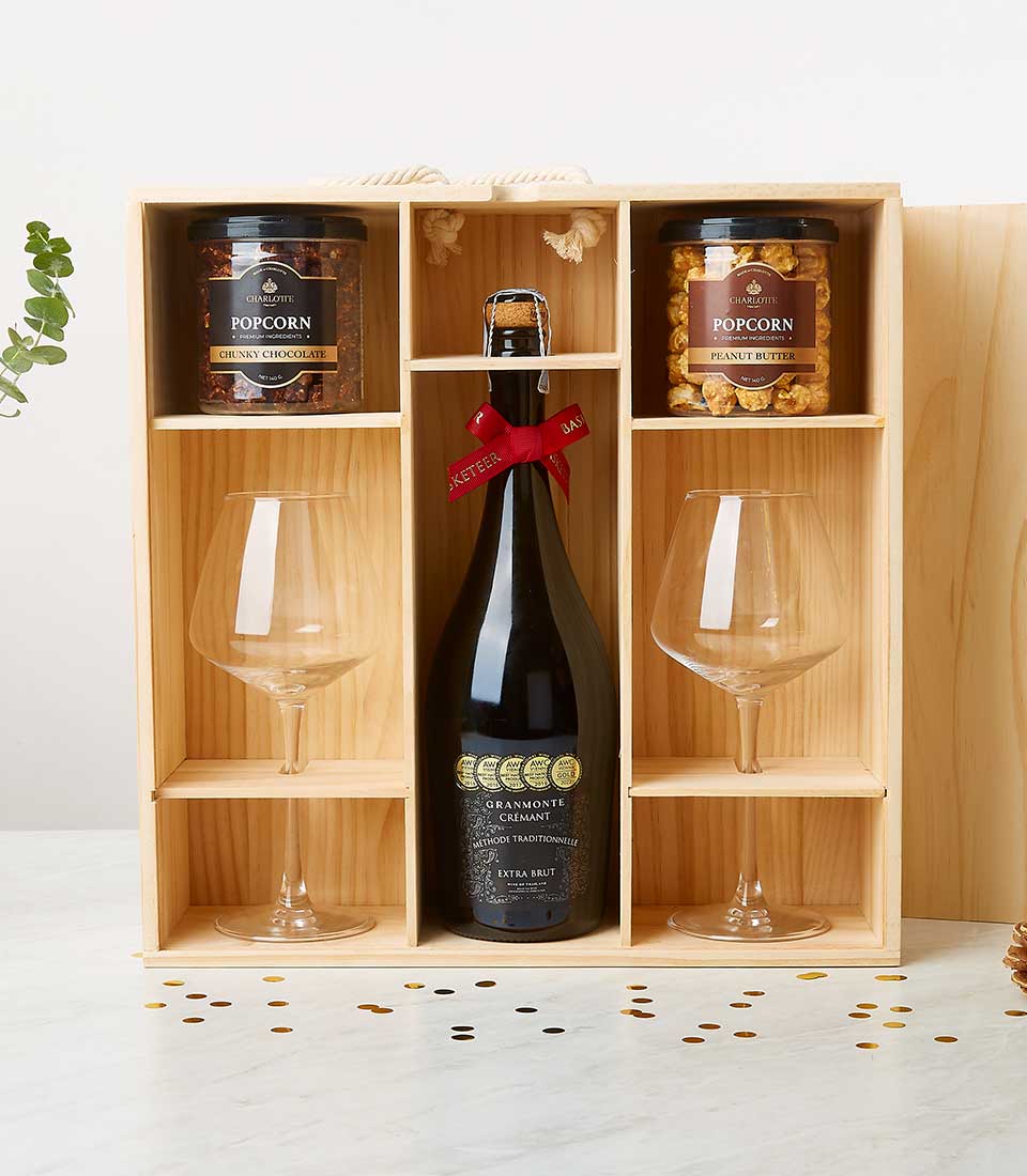 Award-winning Crémant sparkling wine gift box with gourmet popcorn, wine glasses, and gold accents