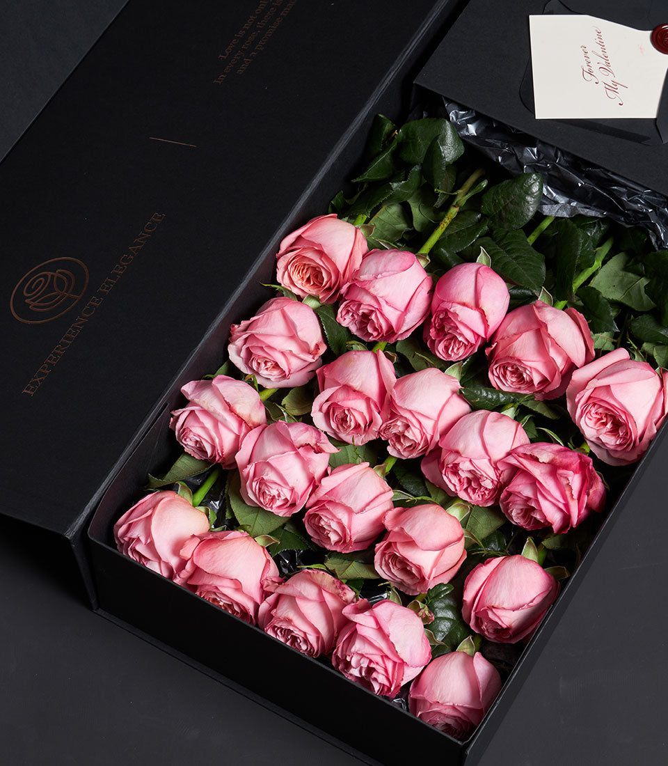 Luxurious black gift box with 18 fresh pink roses and romantic Valentine card with red wax seal