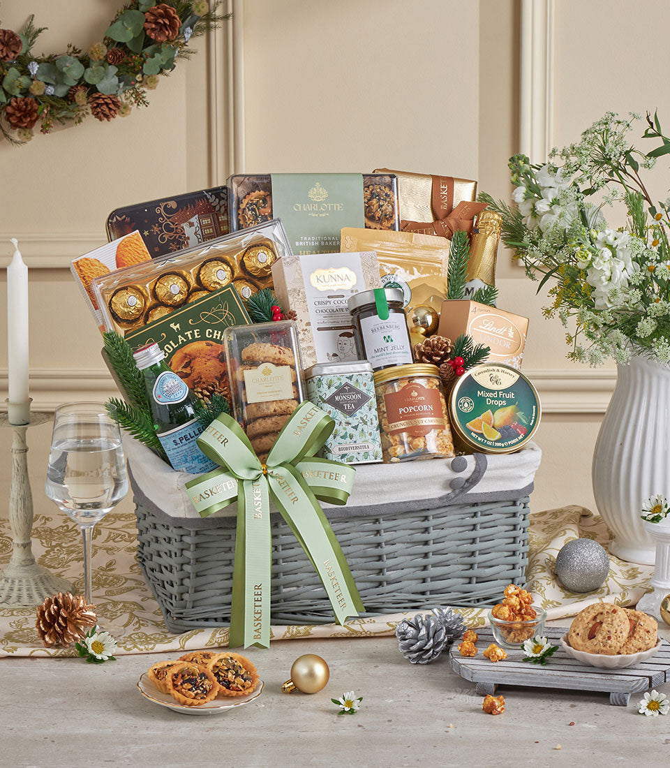 Gold wicker gift basket with champagne, gourmet treats, and festive decorations for New Year celebrations