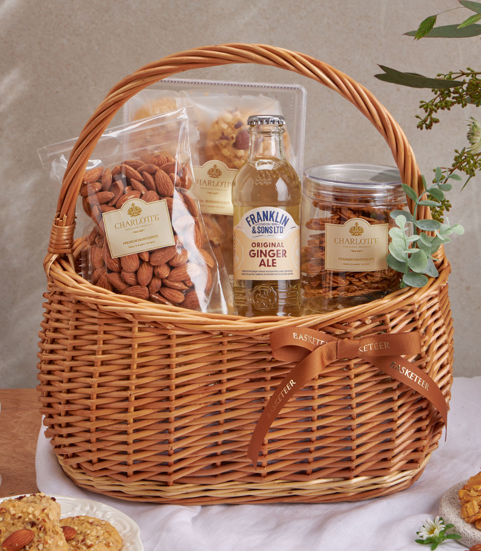 Premium almond cookies and nuts gourmet gift basket with wicker packaging and brown ribbon bow