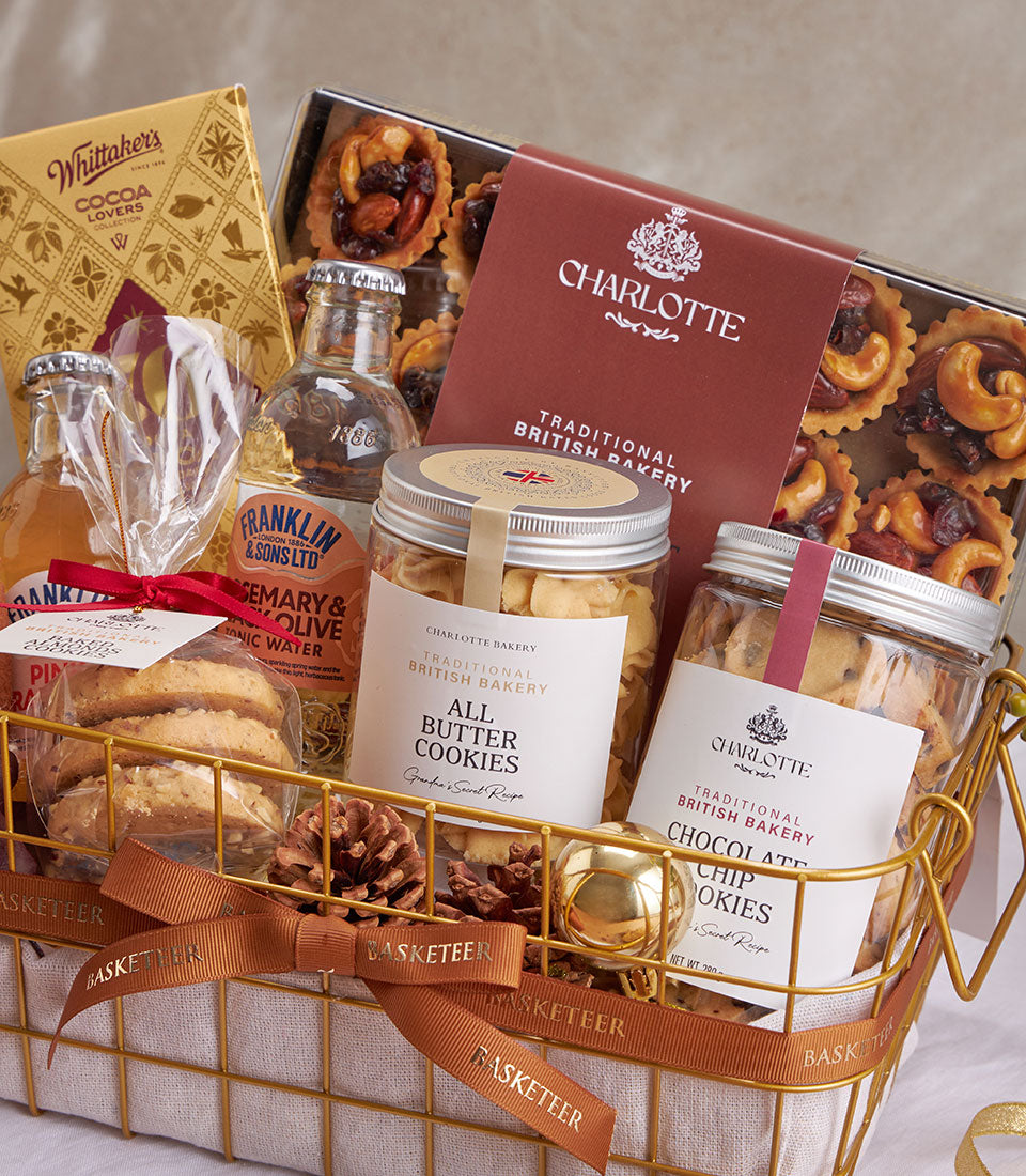 Gold wire mesh gourmet gift basket with British cookies, artisan chocolates, and premium beverages