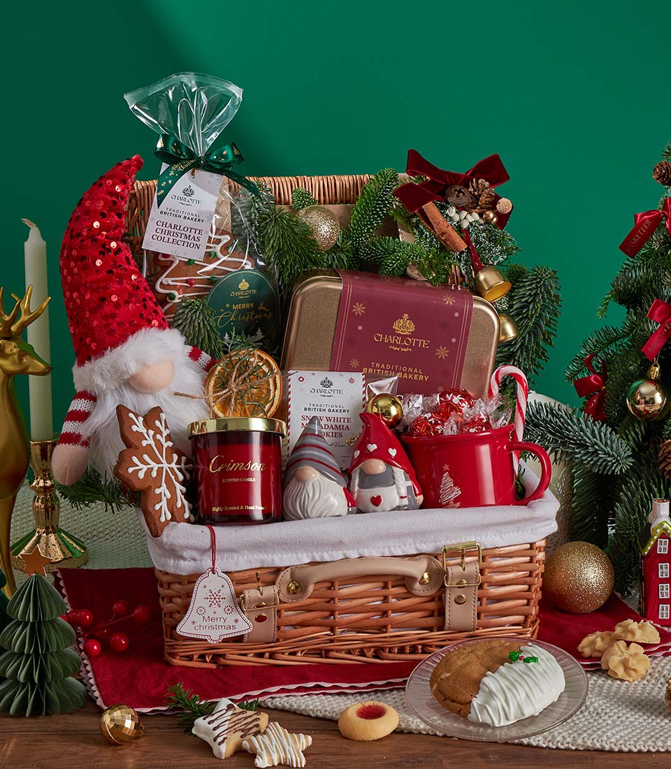 Festive Christmas gift hamper with gingerbread cookies, scented candle, ceramic gnomes, and holiday decorations in woven