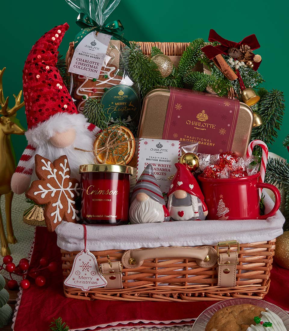 Woven wicker Christmas gift basket with festive gnome, gingerbread cookies, Crimson scented candle, and holiday chocolates