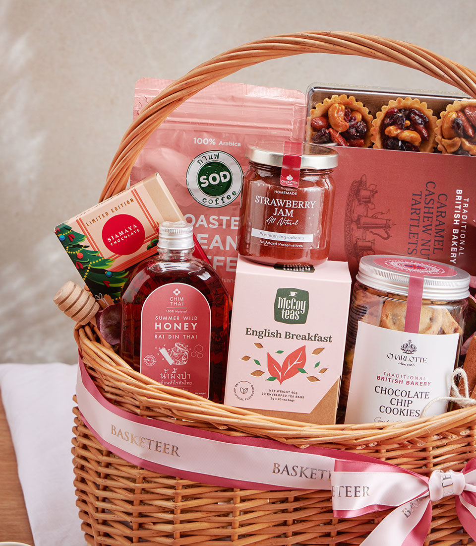 Woven wicker gift basket with Arabica coffee, English breakfast tea, strawberry jam, honey, cookies, and artisan chocolates