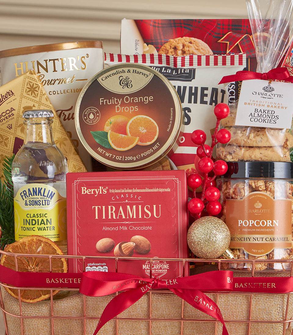 Rose gold wire mesh gift basket with tiramisu chocolates, gourmet treats, and festive red ribbon for New Year gifting