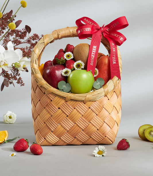 Premium woven fruit basket with Dazzle apples, strawberries, and citrus, tied with red Basketeer ribbon