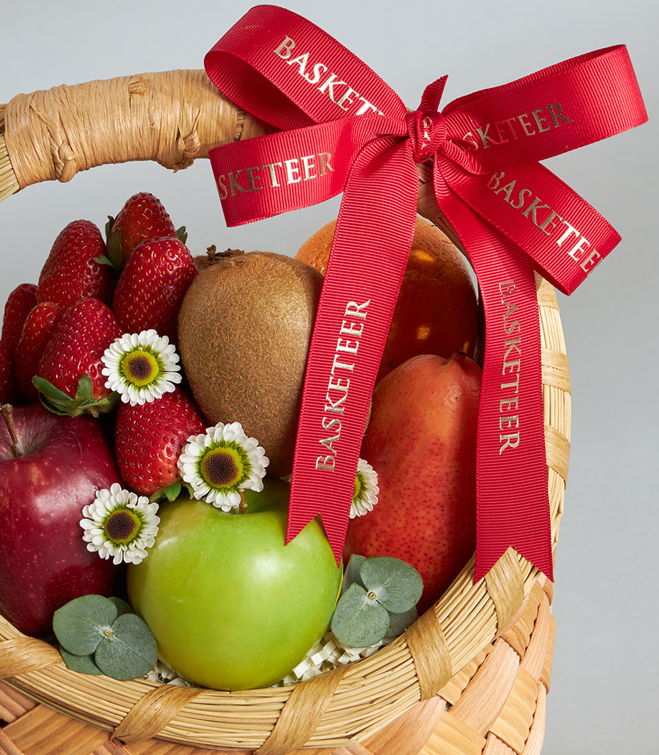 Premium woven fruit basket with Dazzle apples, strawberries, kiwi, and pear, adorned with daisies and eucalyptus