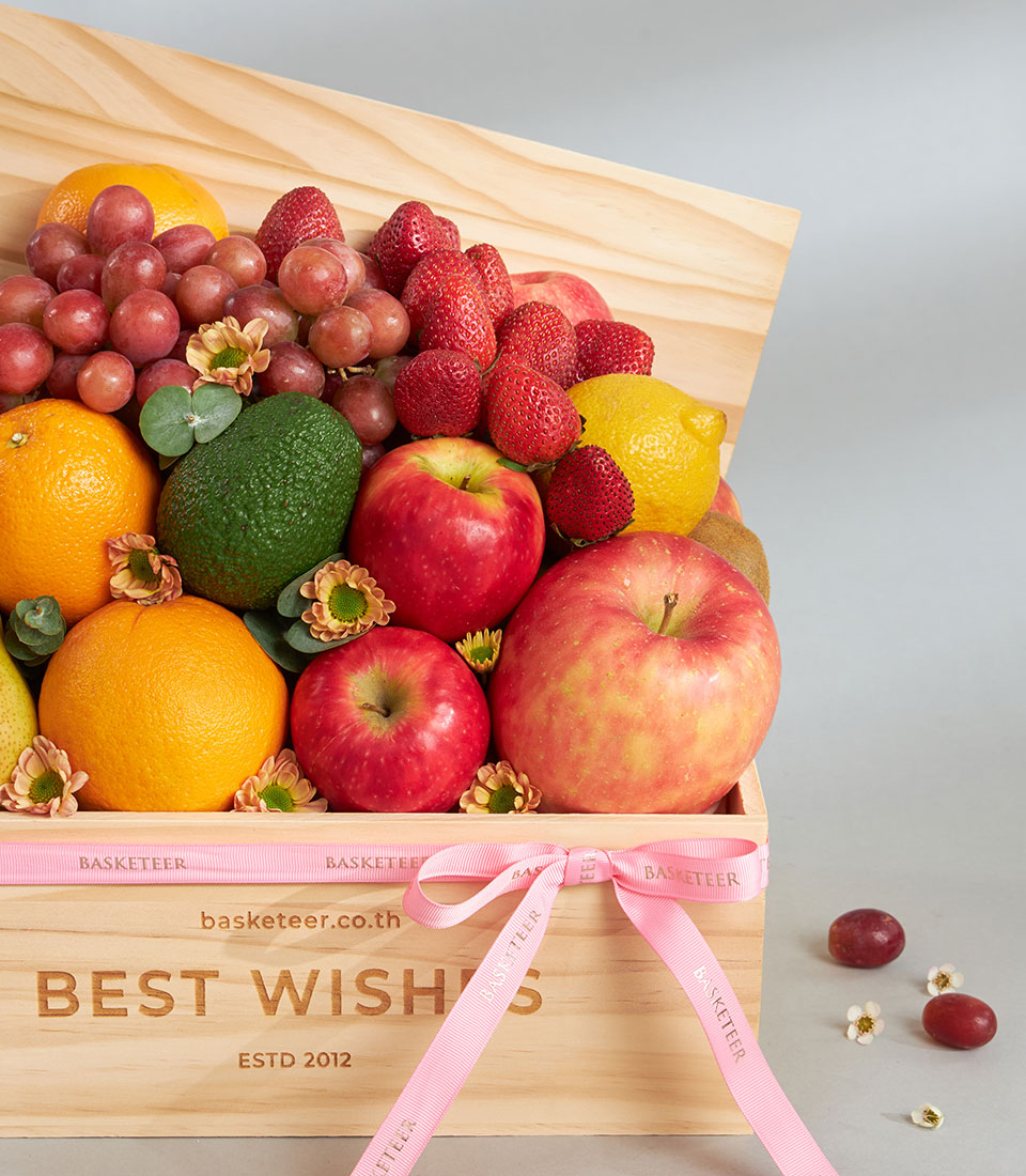 Premium fresh fruit assortment in light wood gift box with pink ribbon bow
