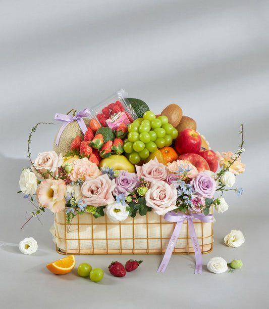 Luxury gold wire fruit and flower basket with fresh strawberries, grapes, citrus, and pastel pink and lavender roses