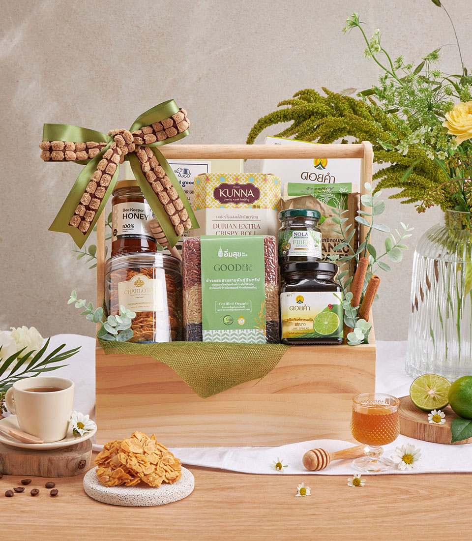 Wooden gift basket filled with healthy coffee, honey, wellness foods and Doi Kham fruits with green ribbon bow