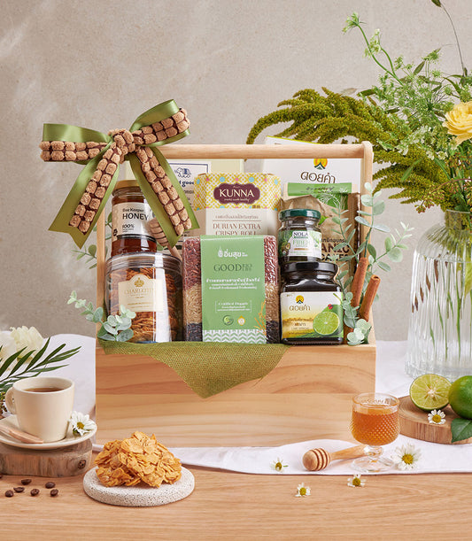 Wooden gift basket filled with healthy coffee, honey, wellness foods and Doi Kham fruits with green ribbon bow