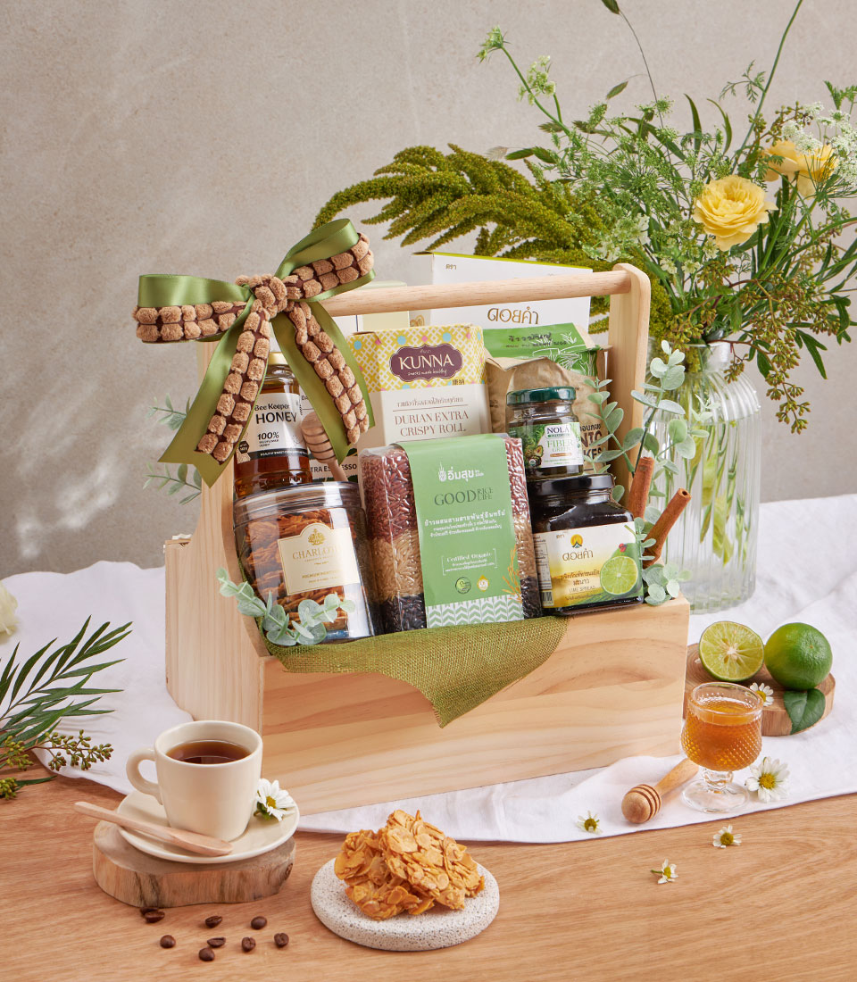 Premium wellness gift basket with honey, rice, spreads and healthy coffee in wooden hamper with green ribbon