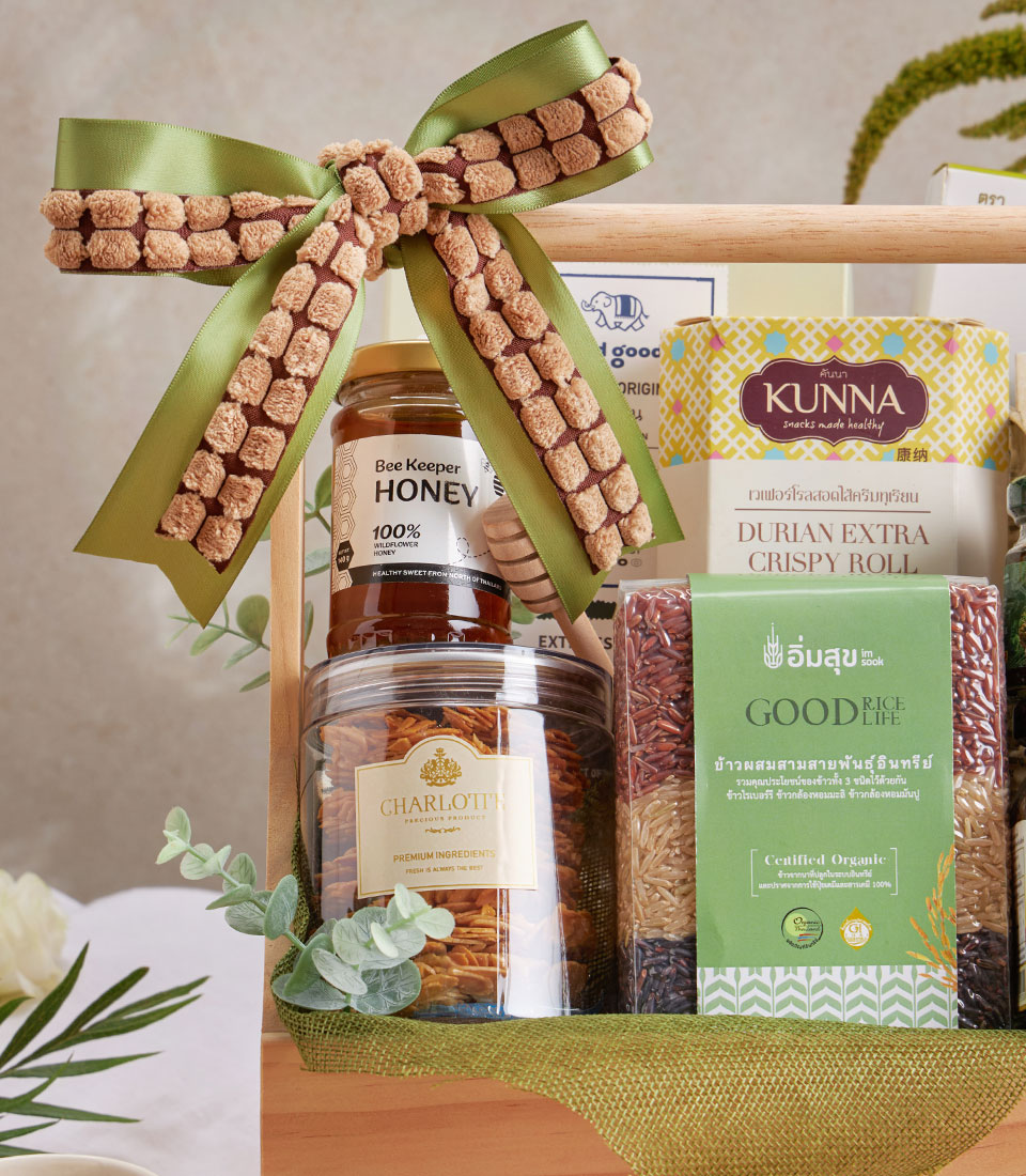 Premium wellness gift basket with coffee, Doi Kham fruits, honey, and gourmet snacks tied with green satin ribbon
