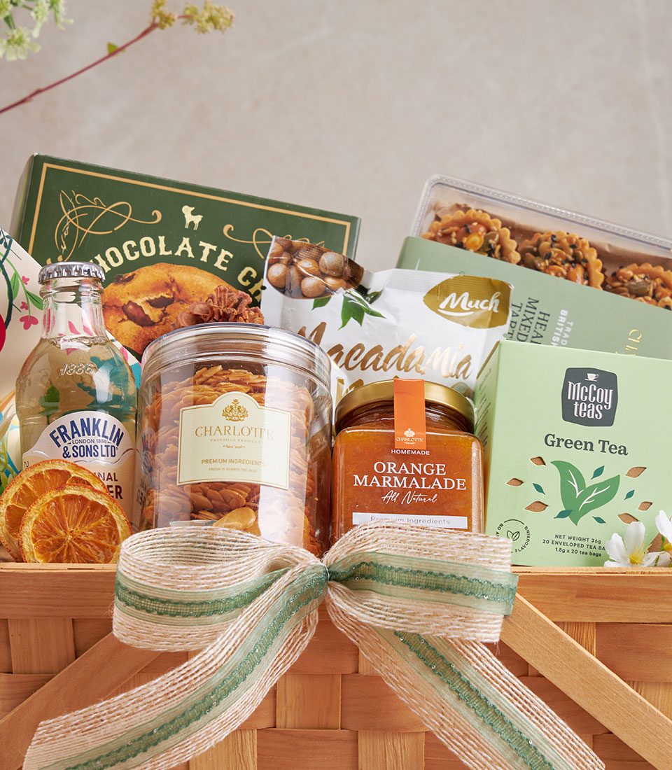 Premium gift basket with gourmet cookies, macadamia nuts, green tea and artisan treats in woven basket