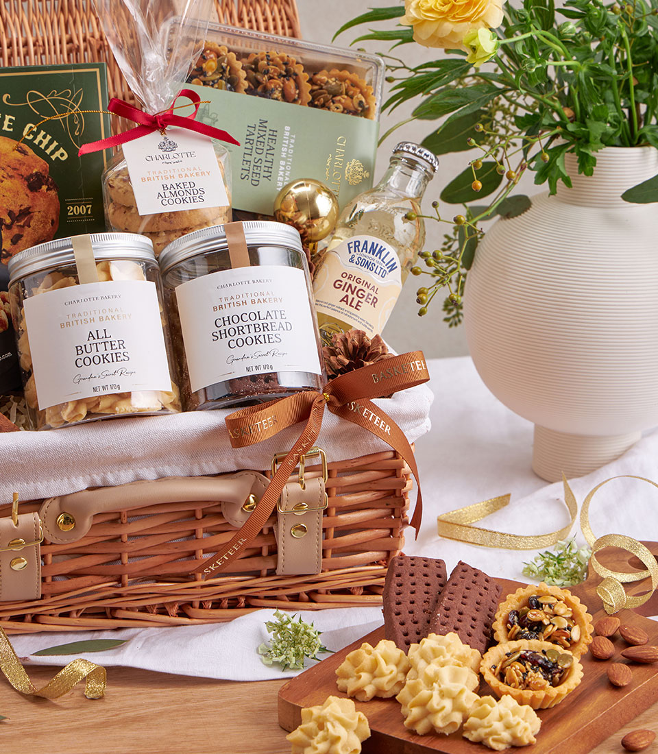 Premium British cookies and gourmet treats hamper in wicker basket with ginger ale and gold accents