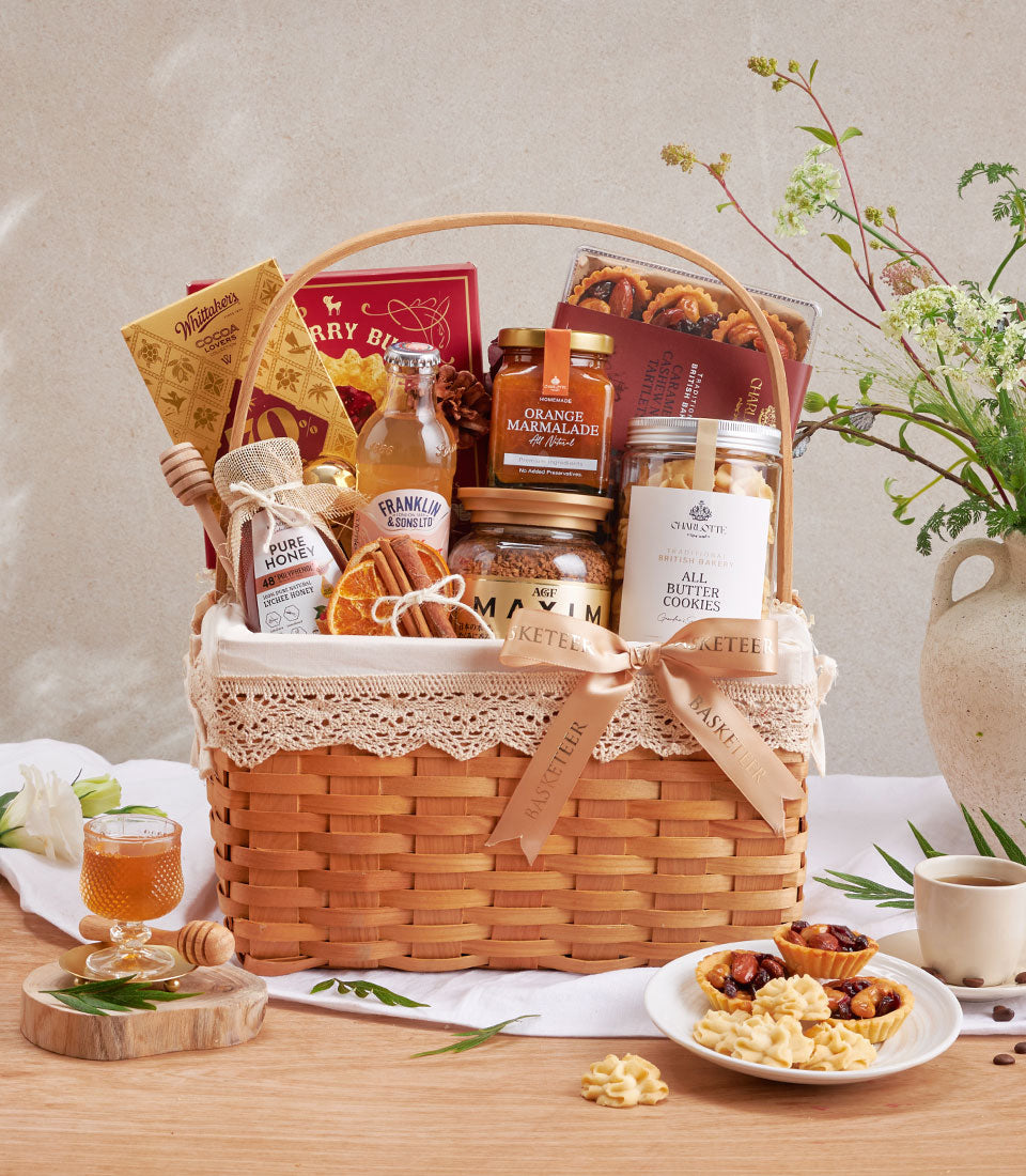 Woven gift basket with raspberry cookies, lychee honey, gourmet chocolates, and artisan treats in champagne ribbon