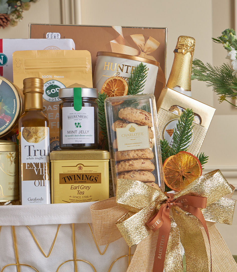 Gold luxury gift basket with champagne, gourmet treats, and festive bow for New Year celebrations