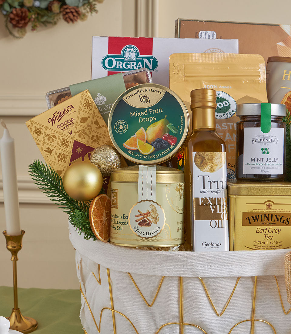 Gold premium gourmet gift basket with chocolate, truffle oil, Earl Grey tea, and holiday baubles for New Year celebrations
