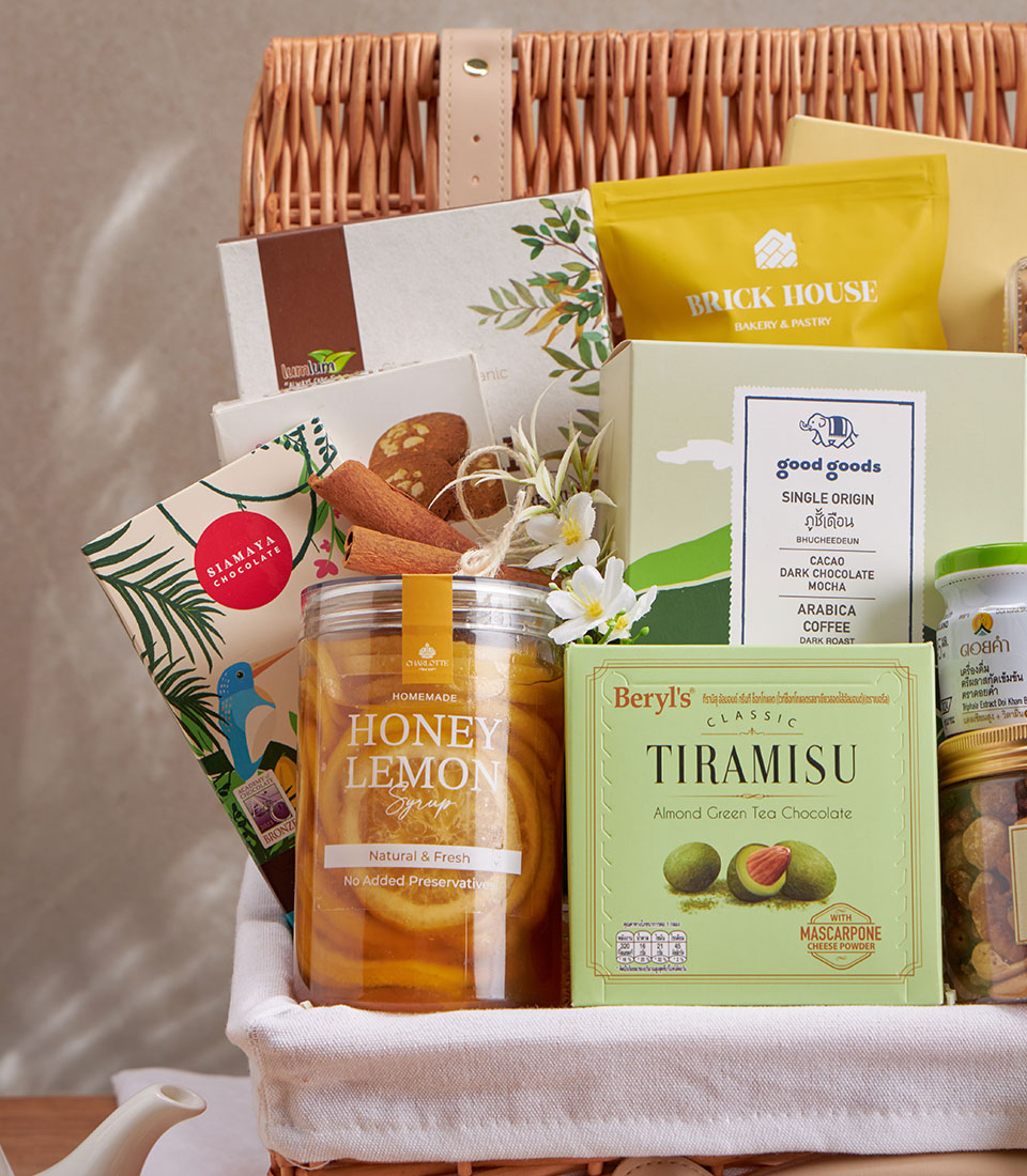 Woven wicker luxury wellness gift basket with honey lemon syrup, artisan chocolate, specialty coffee, and gourmet treats