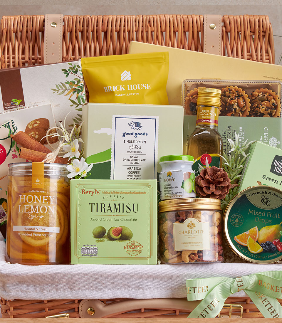 Luxury wellness gift basket with honey lemon syrup, green tea chocolate, single origin coffee, organic coconut, and artisan