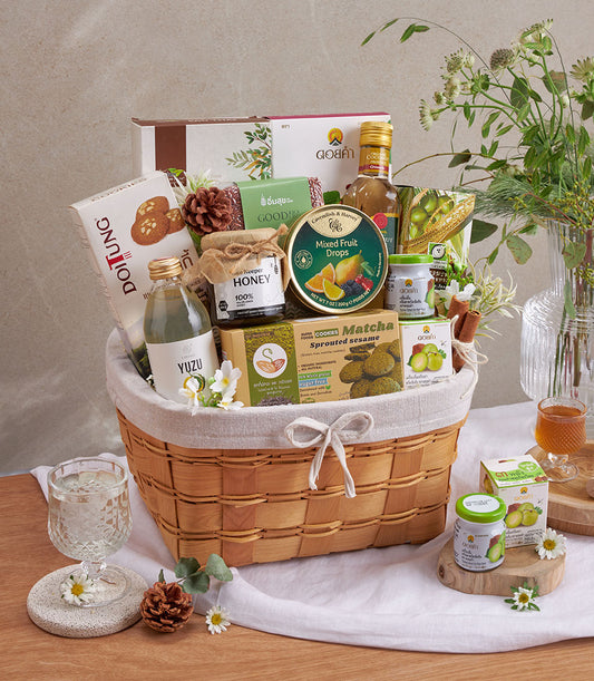 Premium wellness gift basket with organic superfoods, honey, matcha cookies, and artisan beverages in woven wood hamper