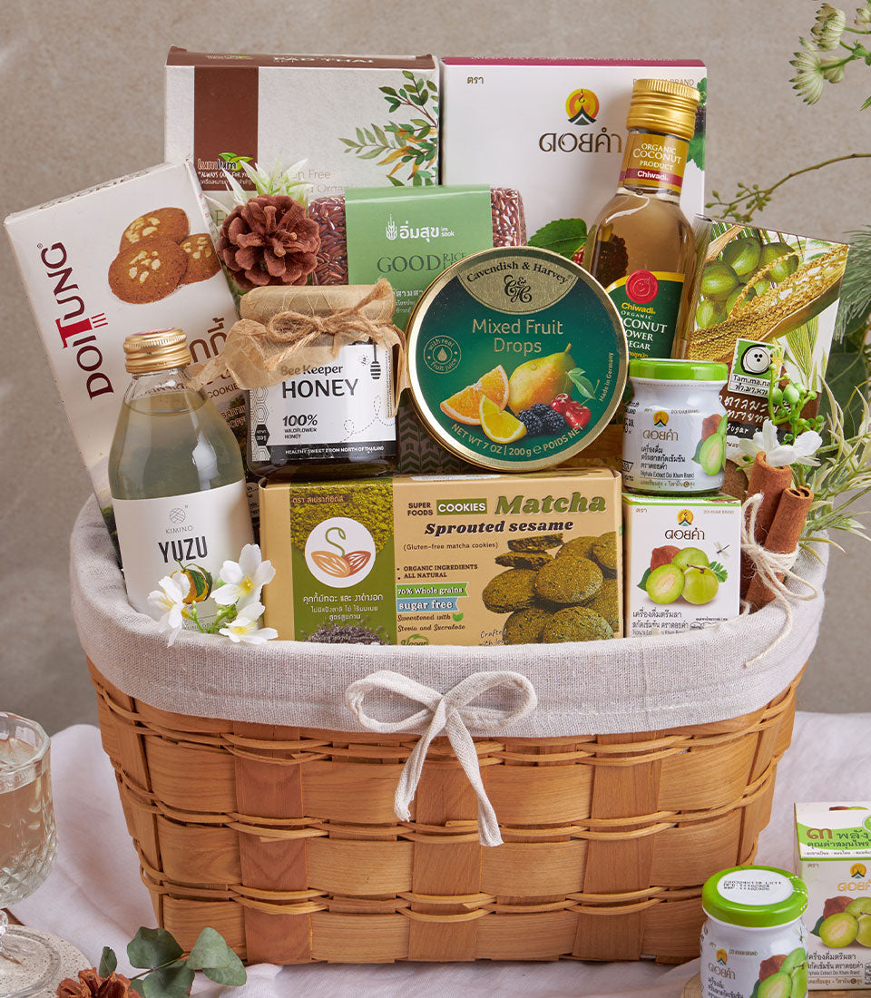 Premium wellness gift basket with organic superfoods, honey, matcha cookies, and yuzu drink in woven wood hamper