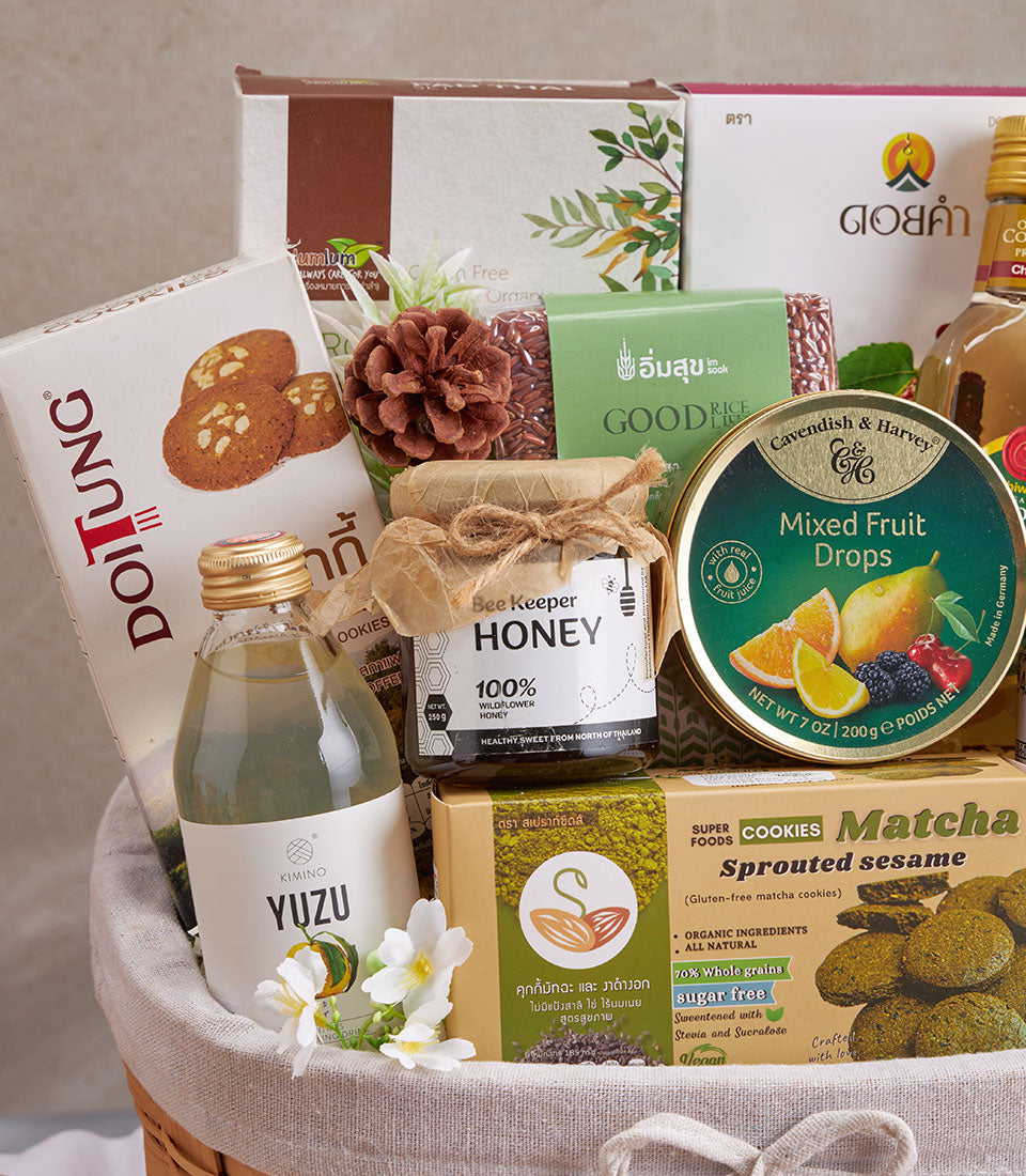 Premium wellness gift basket with organic honey, matcha cookies, yuzu beverage, and superfoods in woven presentation