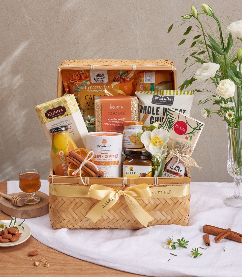 Premium wellness gift basket with organic granola, honey, and natural products in golden-ribbon bamboo hamper