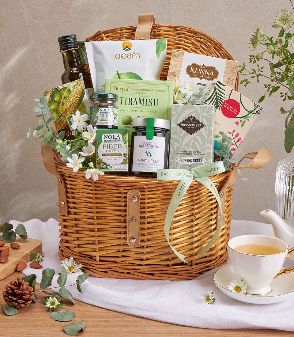 Premium wellness gift basket with olive oil, green tea, and gourmet health foods in wicker with green ribbon