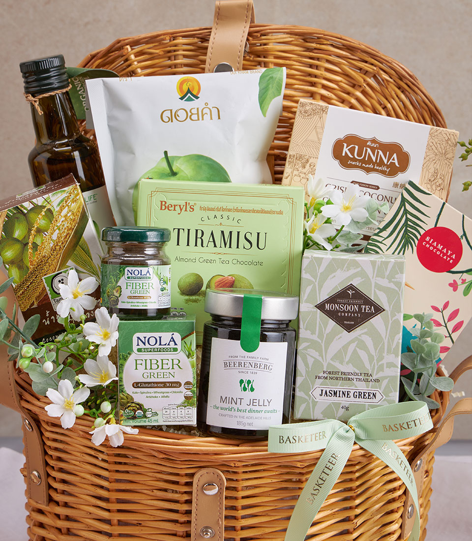 Premium wellness gift basket with olive oil, green tea, healthy snacks, and supplements nestled in woven wicker