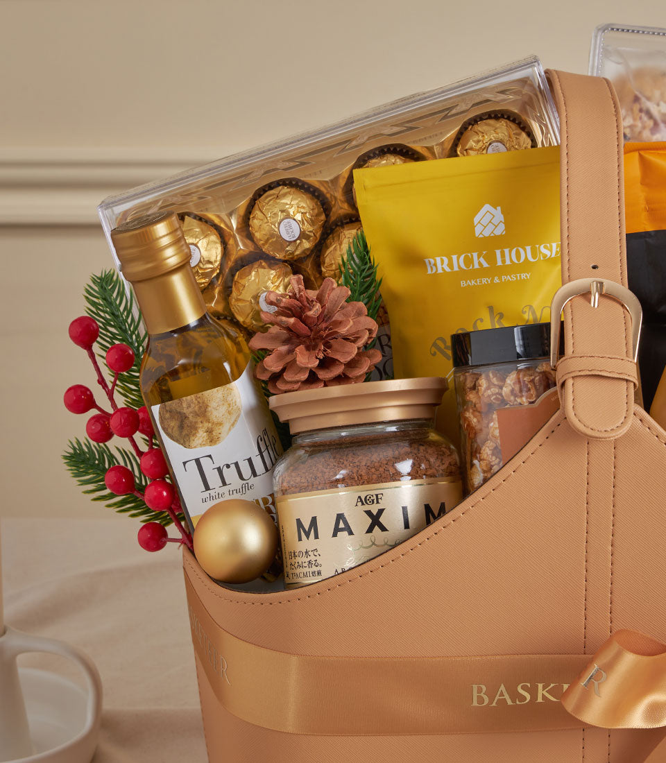 Tan leather luxury gourmet tote with gold chocolates, truffle oil, and artisan coffee for New Year gifting