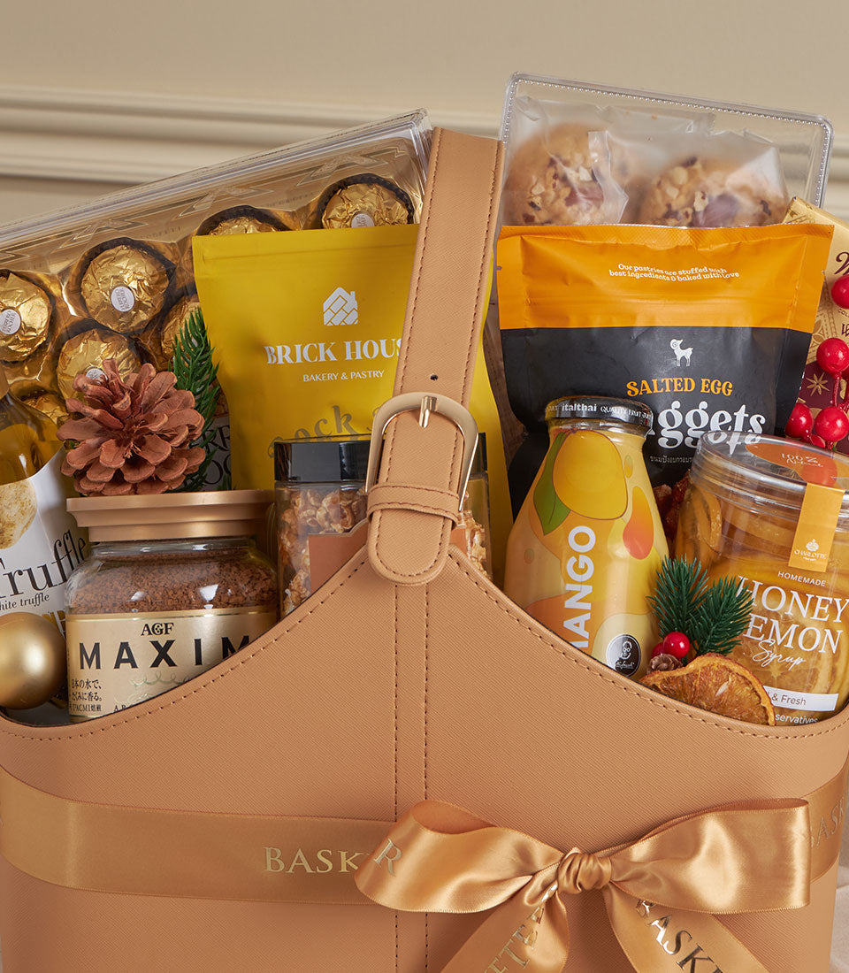 Light tan leather luxury gift tote with gourmet treats, chocolates, and artisan baked goods for New Year gifting